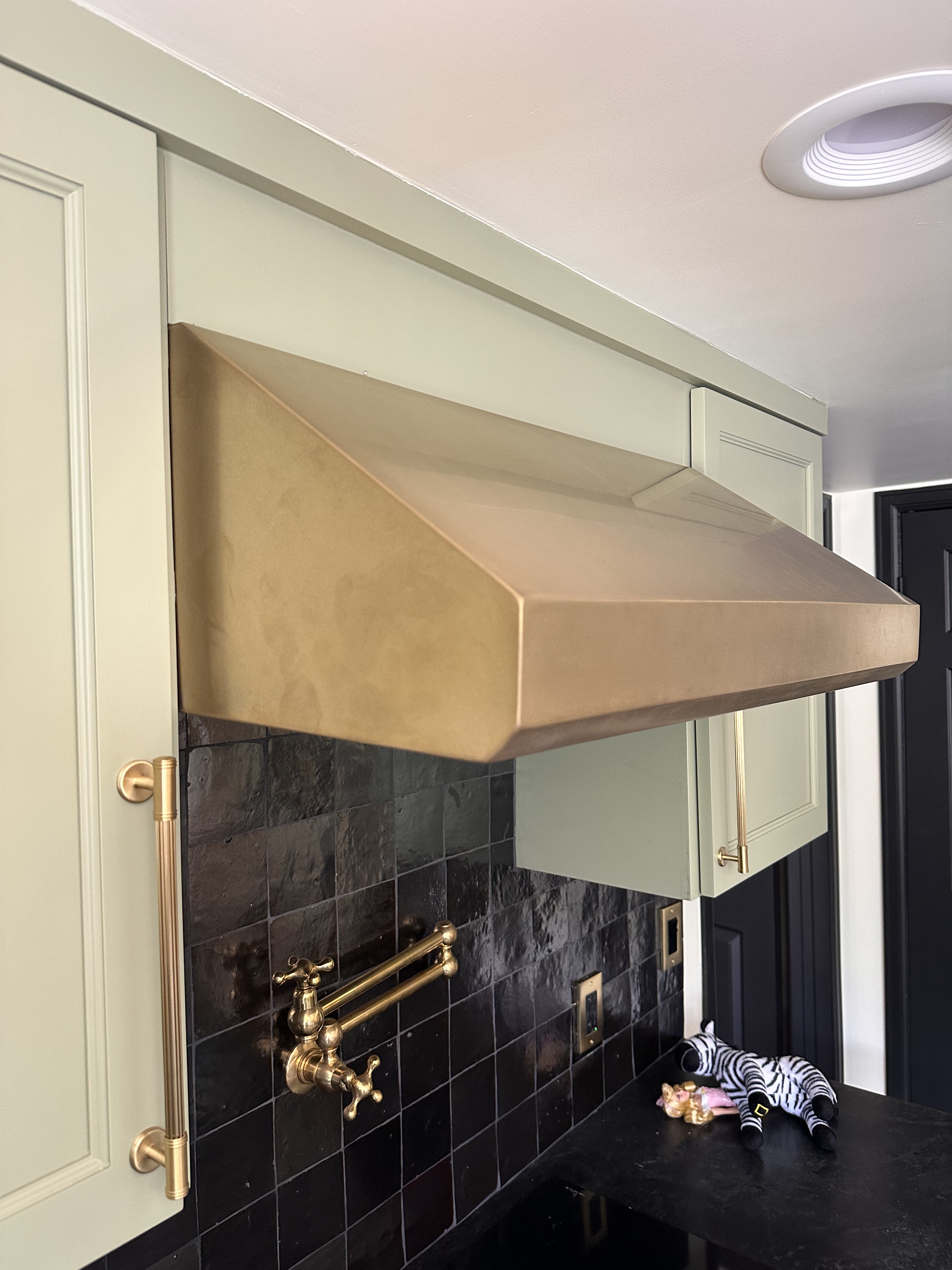 Custom kitchen hood with curved geometry integrated lighting VeroMetal finish